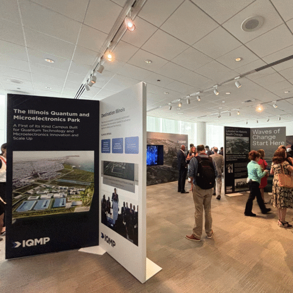 Attendees of the Global Quantum Forum explore the Illinois Quantum and Microelectronics Park and Quantum Shore activation space featuring informational panels on the Park.