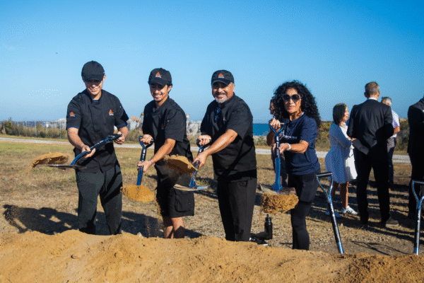 Community member and business owner Jorge Perez stands next to his family as they hold shovels for the IQMP groundbreaking.